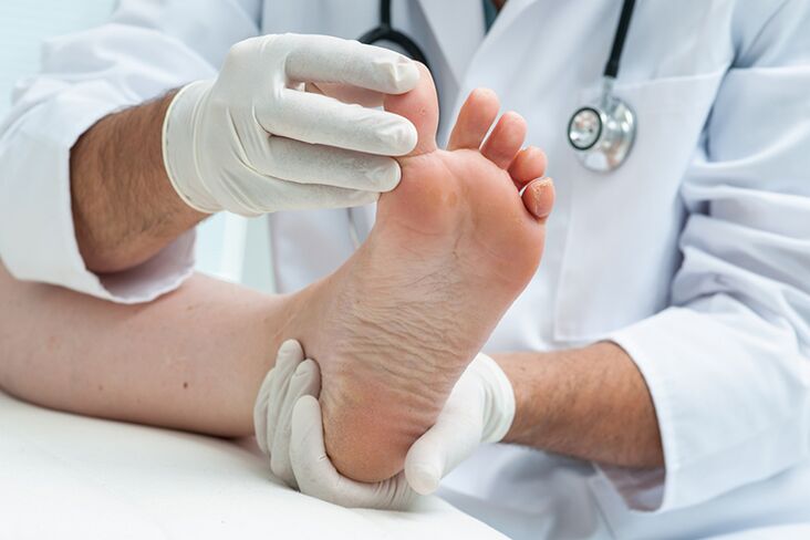 Dermatologe untersucht die Beine des Patienten